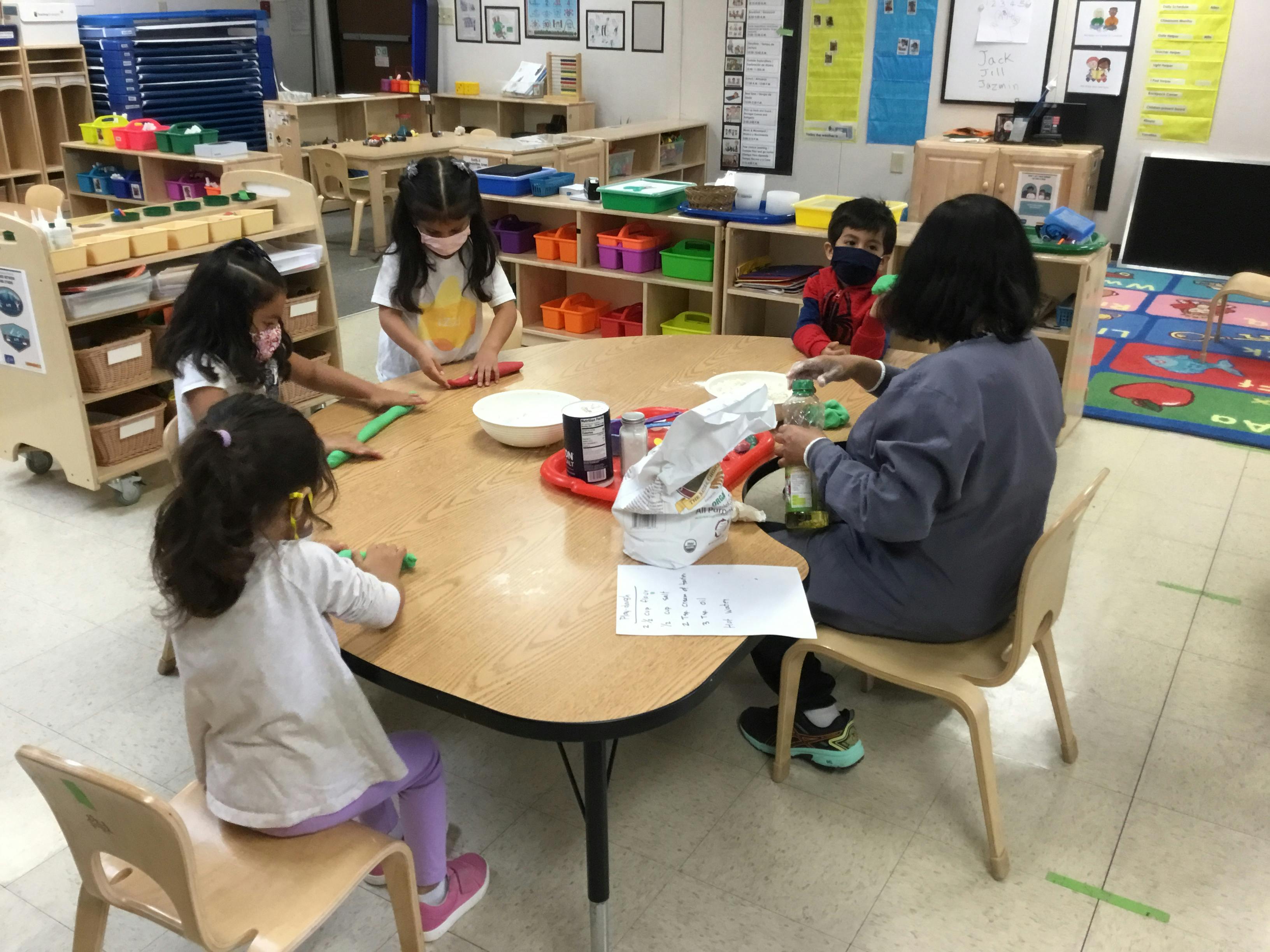 Adult and children at a table in a classroom