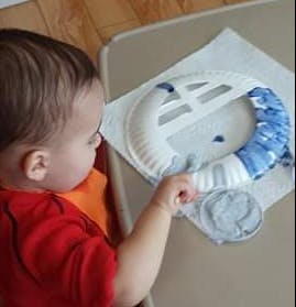 Child painting a paper plate craft