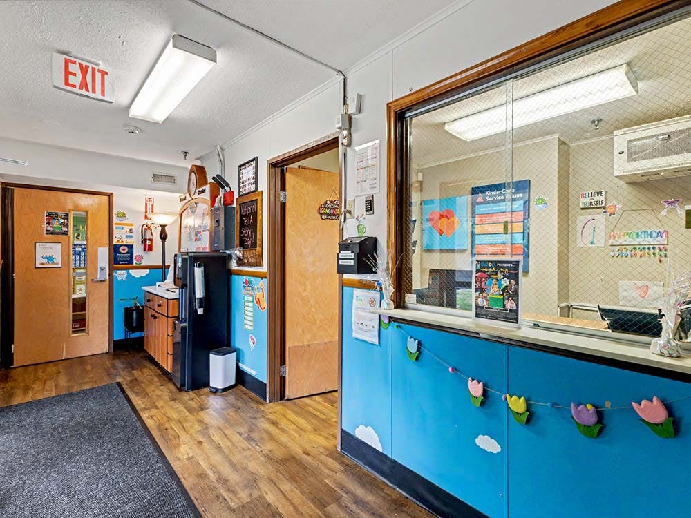 Reception area in a childcare center with a service window and bulletin boards