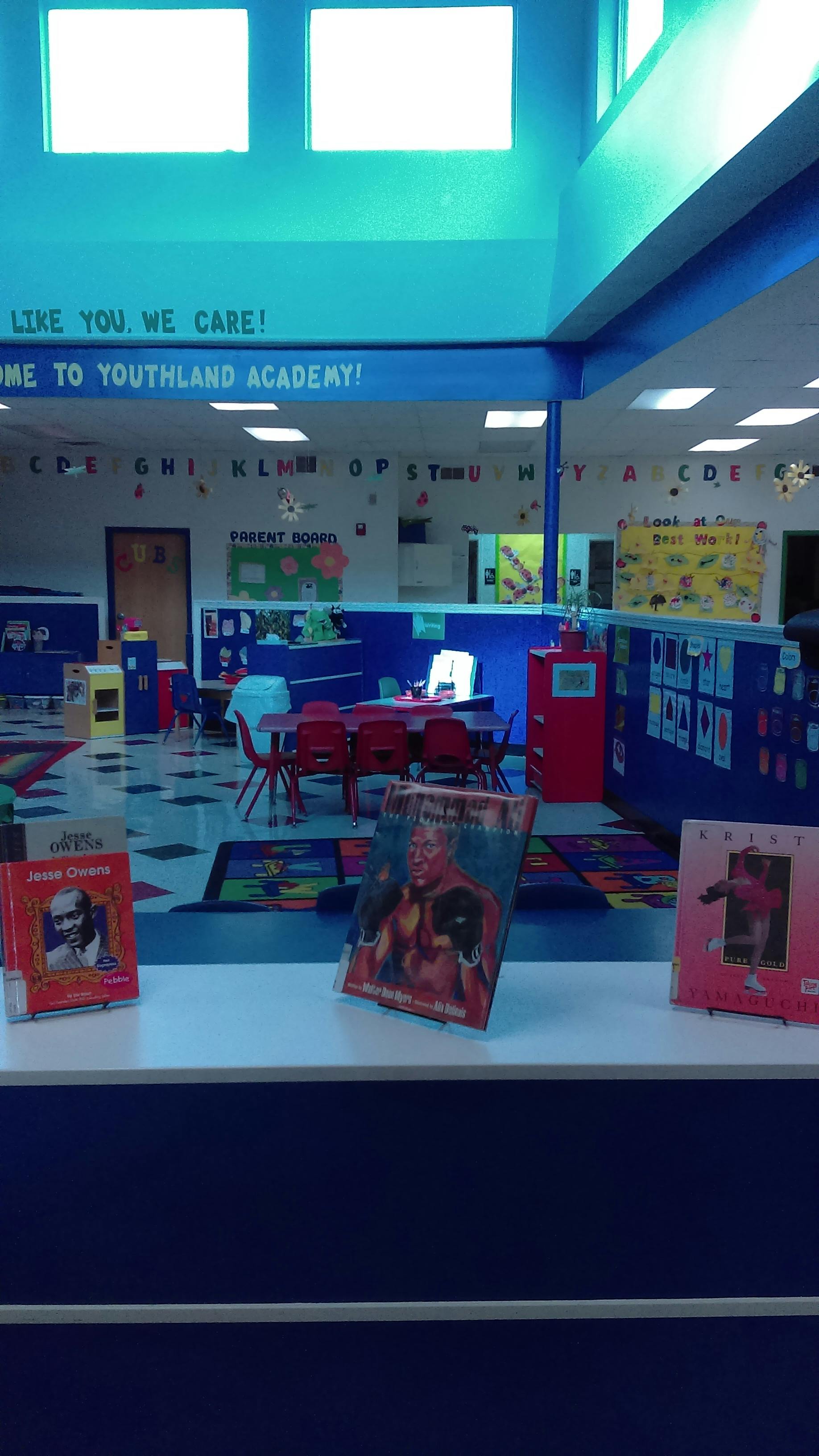 Classroom with tables, chairs, and books on display