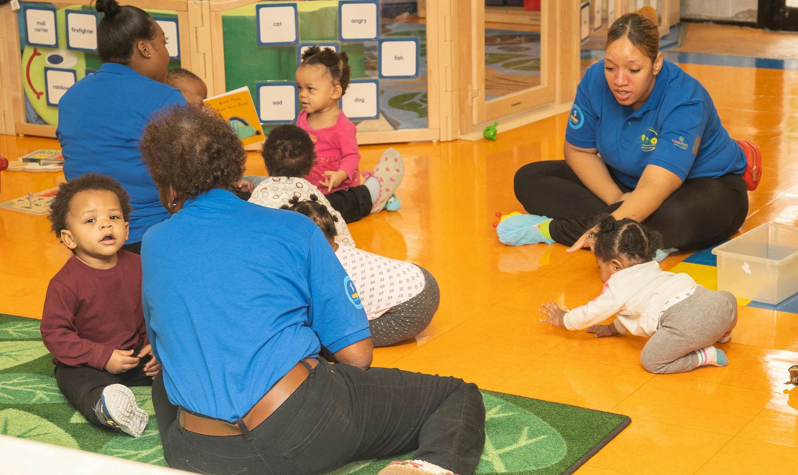 Adults and children sitting on the floor in a classroom