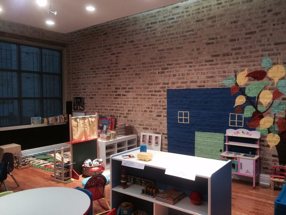 Classroom with brick wall, large window, and play furniture