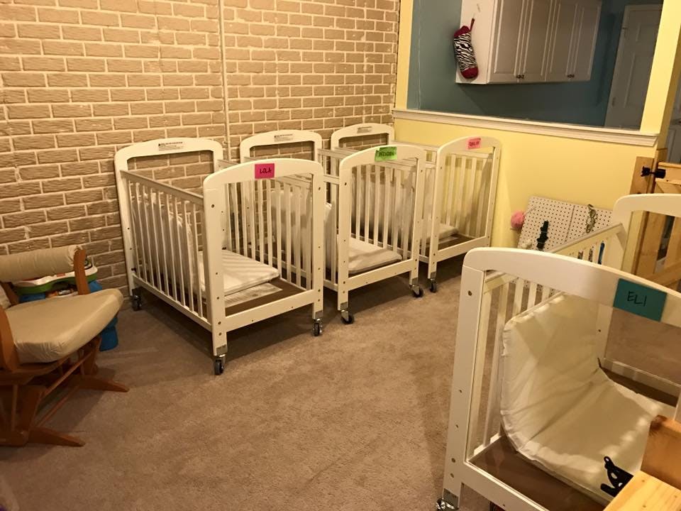 Multiple white cribs in a room