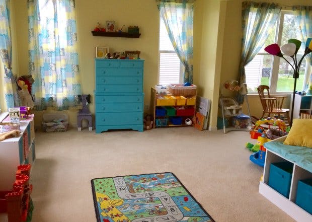 Playroom with a blue dresser, toy storage, and a road map rug