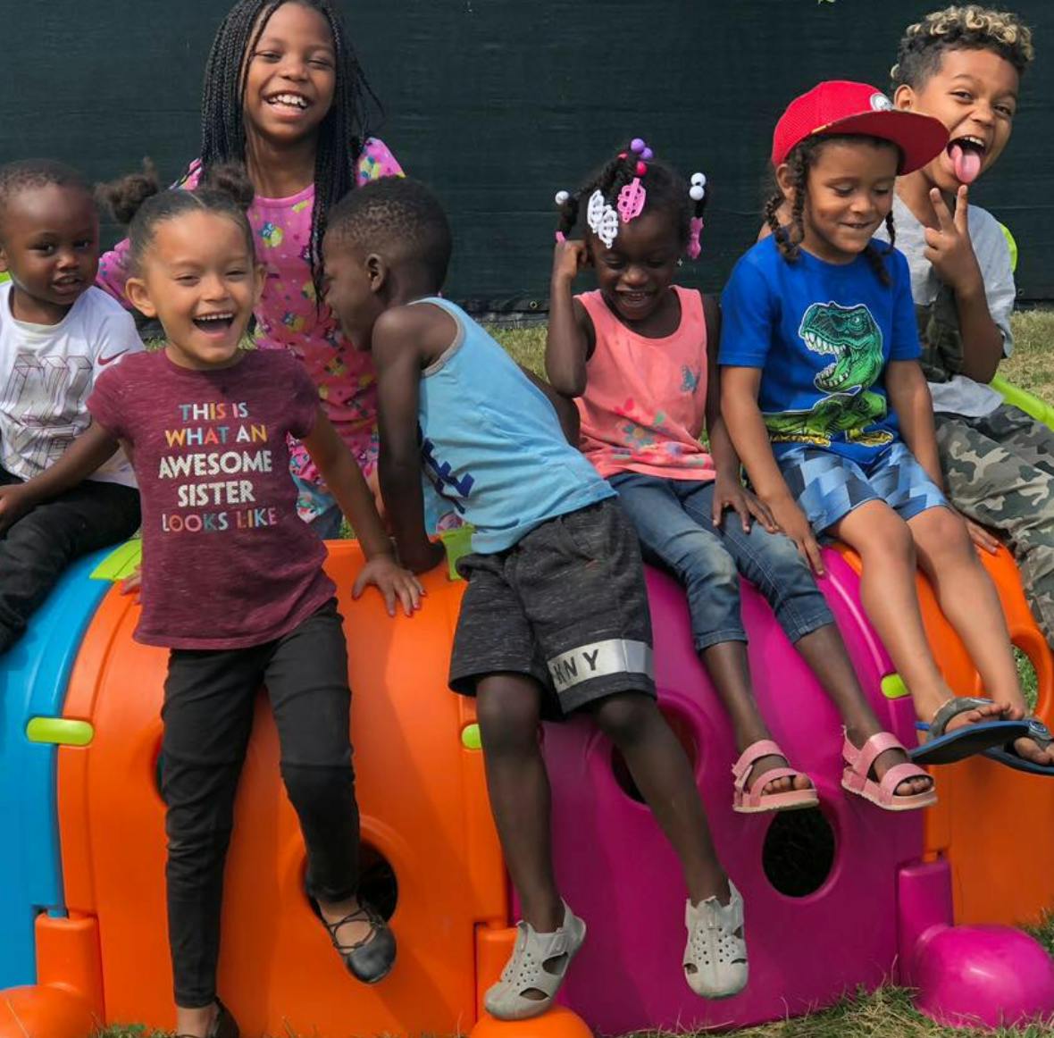 Group of children playing on a colorful plastic play structure