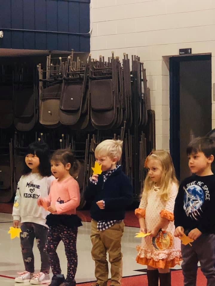 Children holding yellow paper leaves