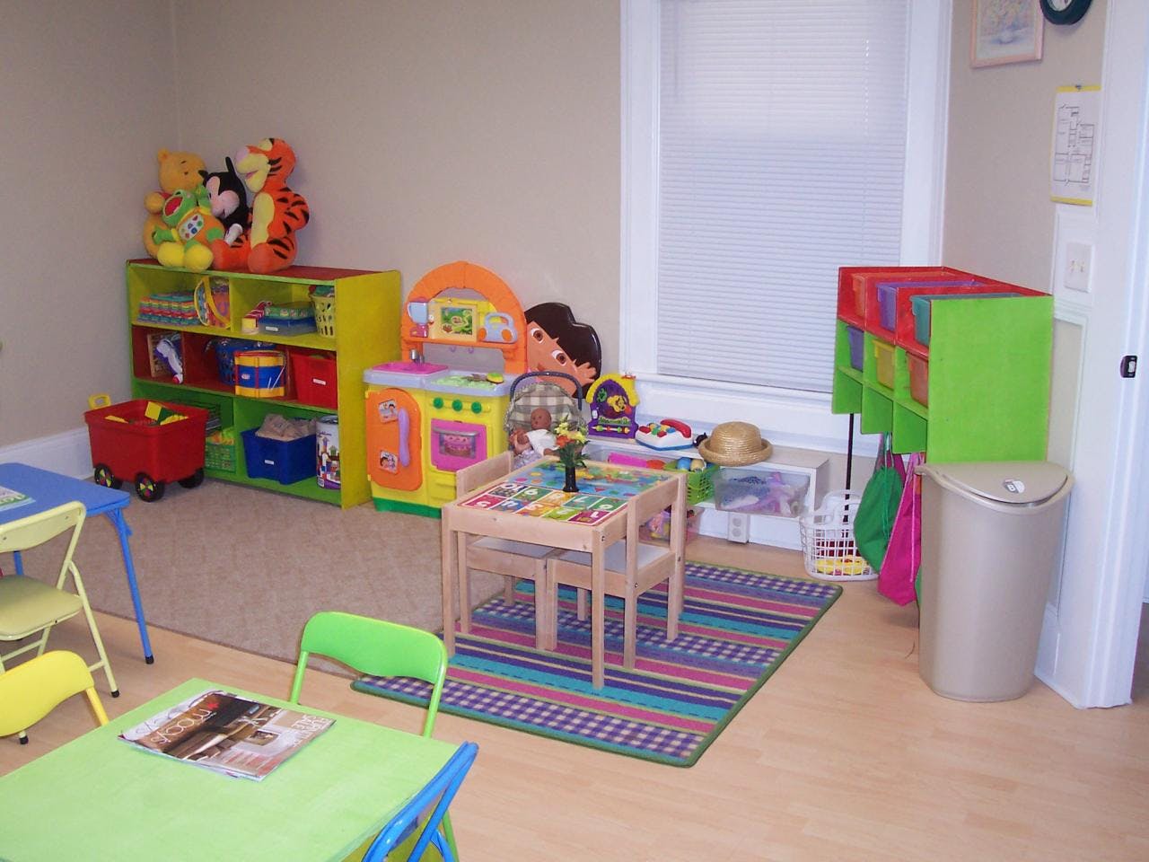 Children's play area with small tables, chairs, and toy storage