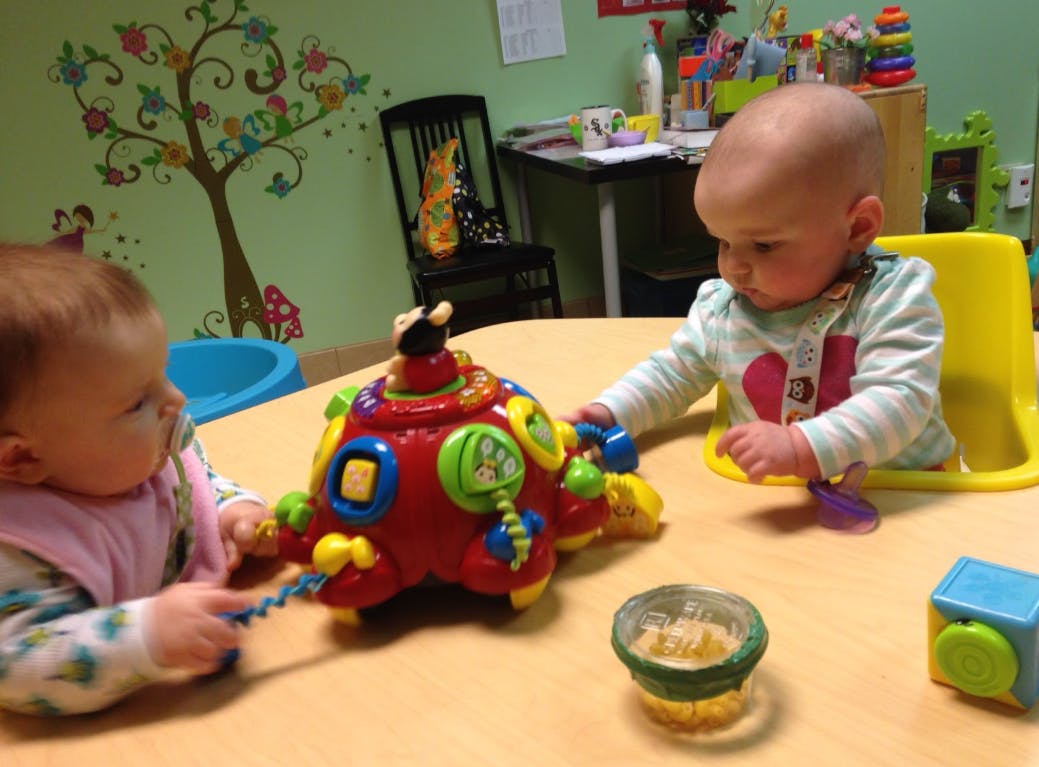 Two children playing with a colorful toy on a table