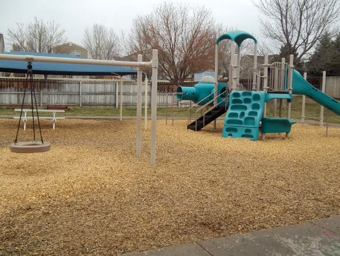 Playground with wood chips, swings, slides, and climbing structures