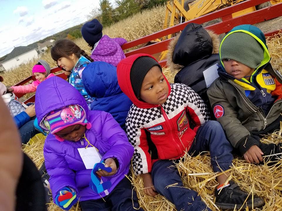 Children sitting on hay in a wagon