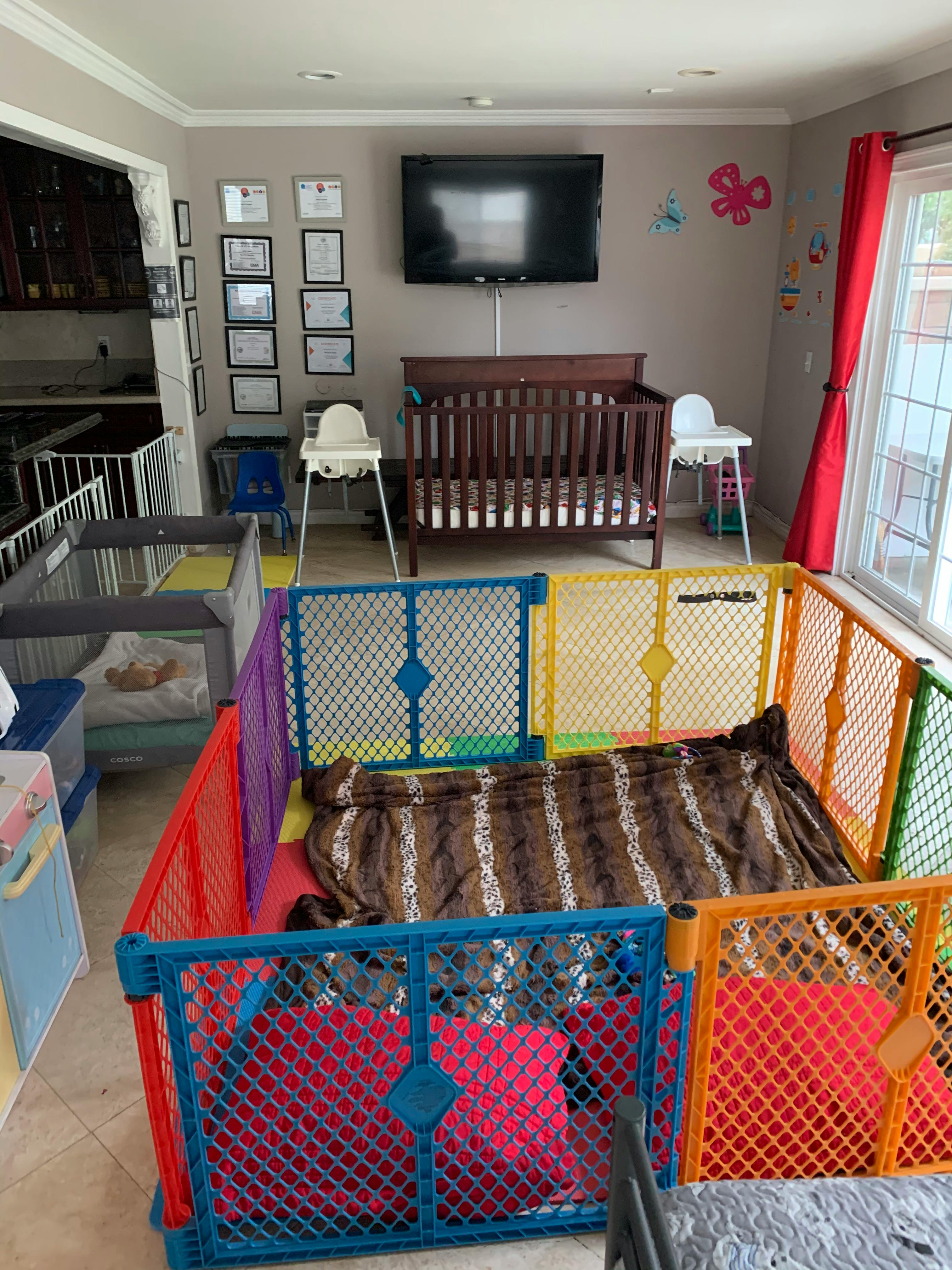 Playpen with blankets and cribs in a room