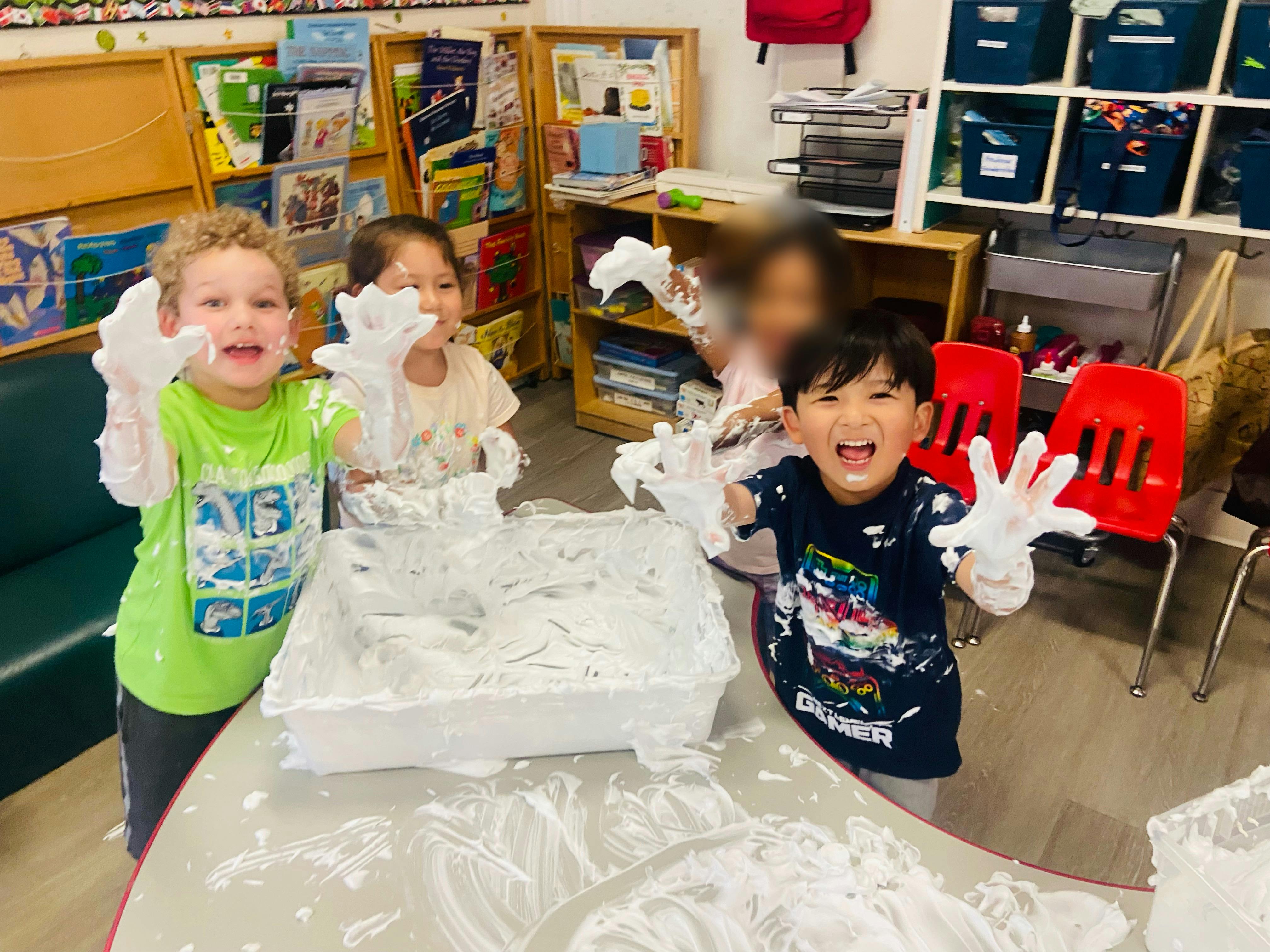 Children playing with shaving cream in a classroom
