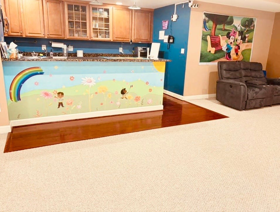 kitchen counter with children and rainbow mural, recliner chair, and large rug