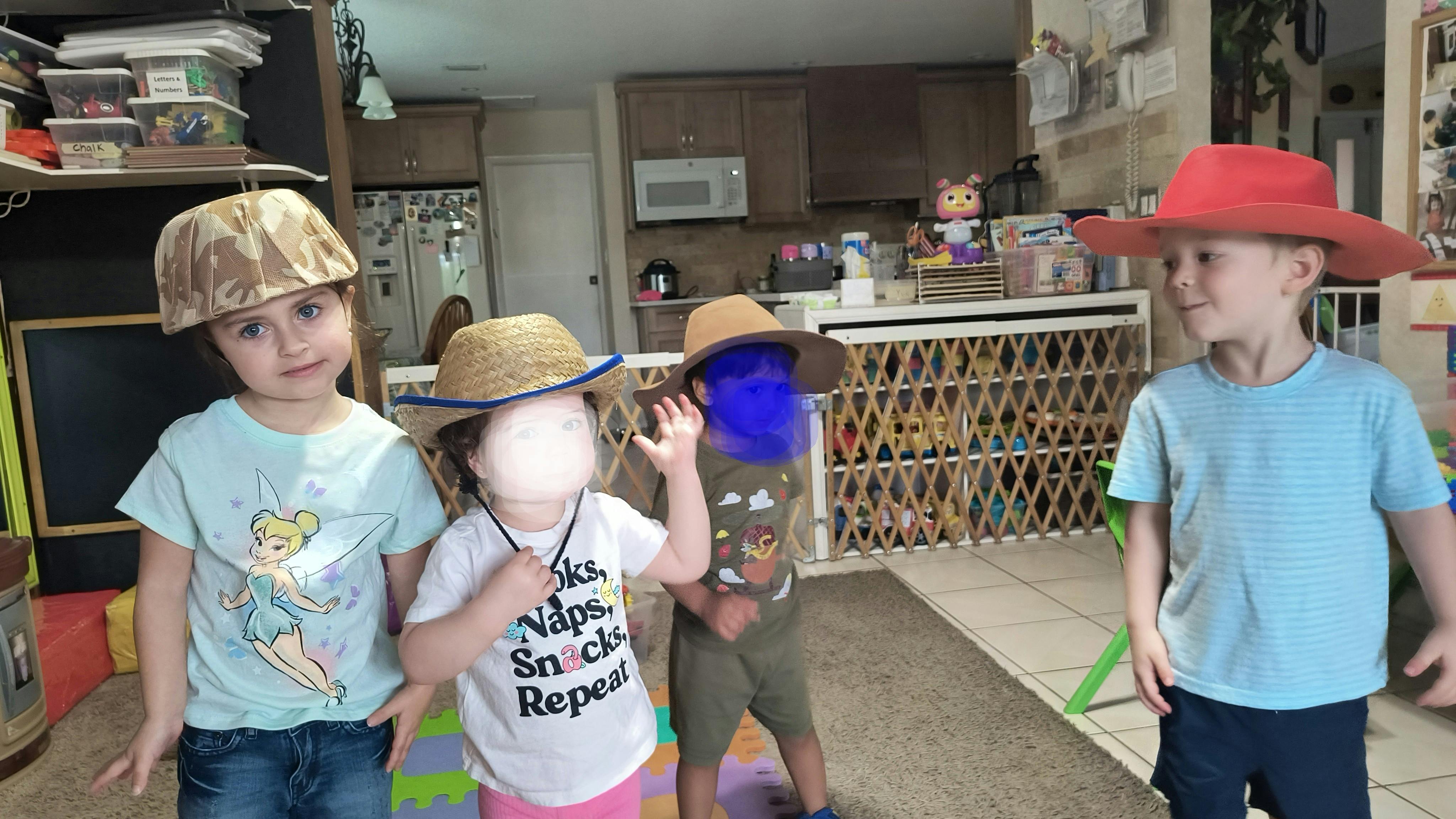 Four children wearing hats indoors
