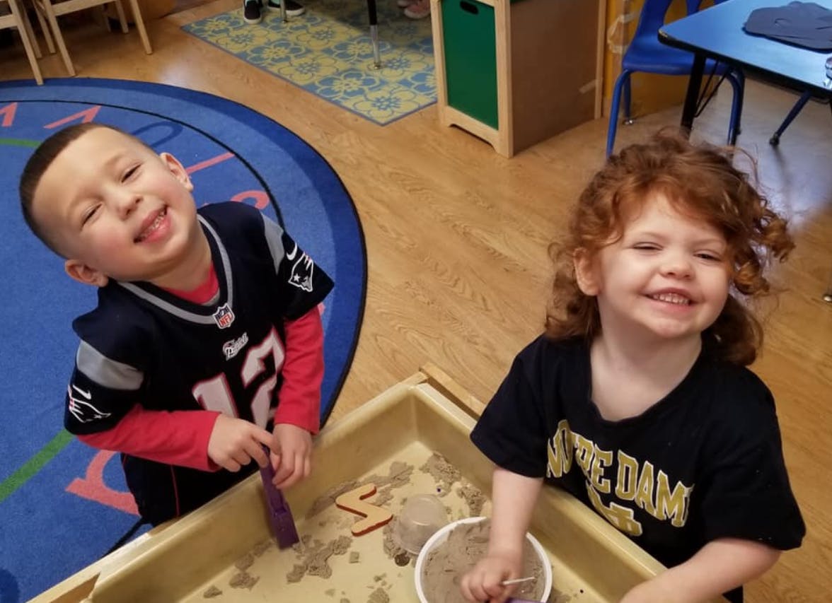Two children playing in a sand table