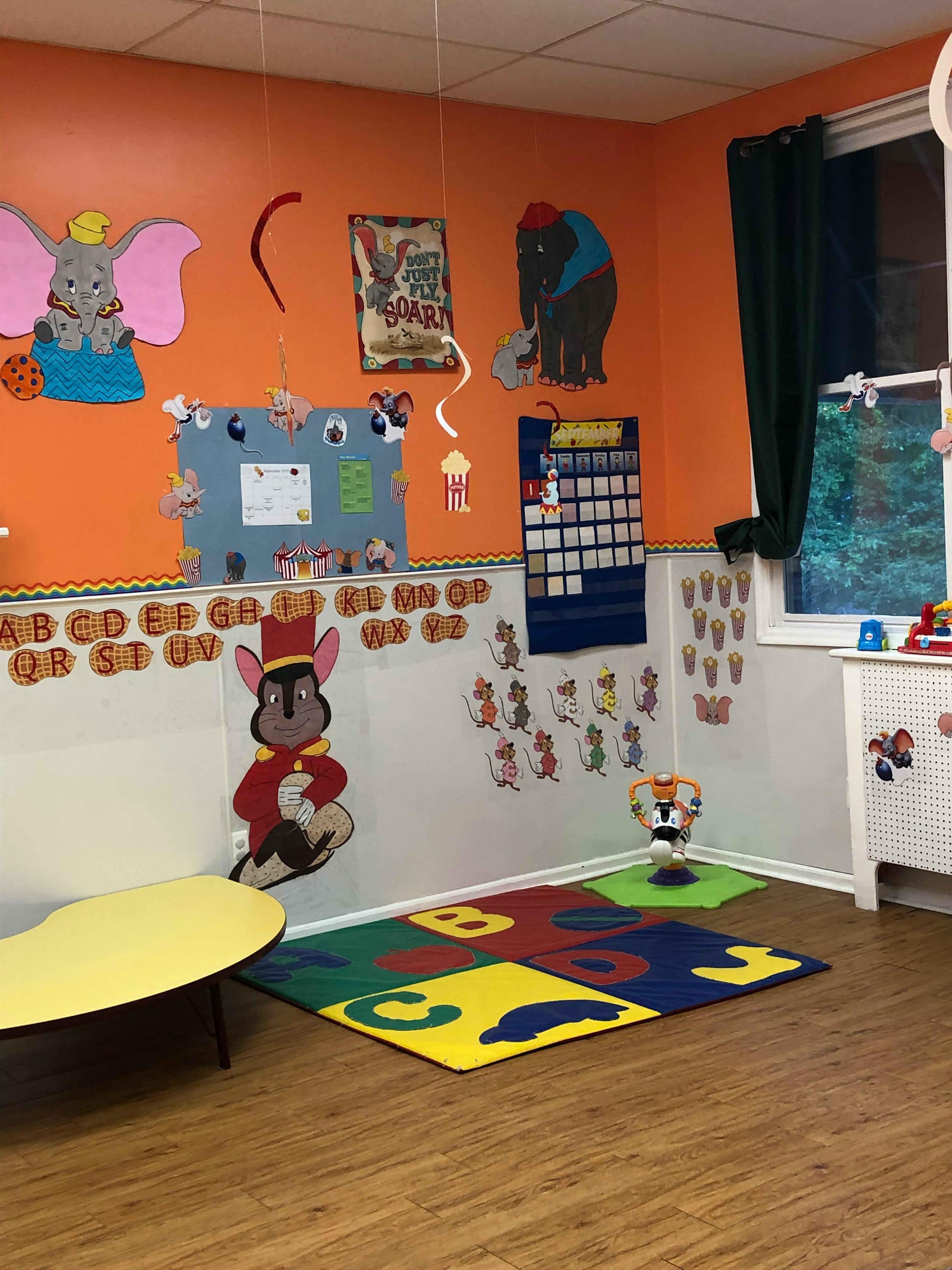 Classroom with colorful decorations, alphabet letters, and a play rug