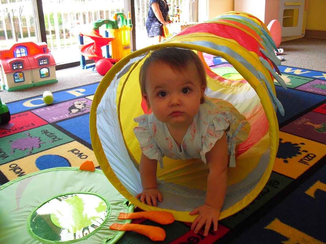 Child crawling out of a colorful play tunnel