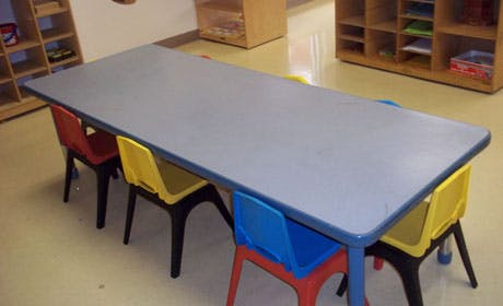 Long table with colorful chairs in a classroom