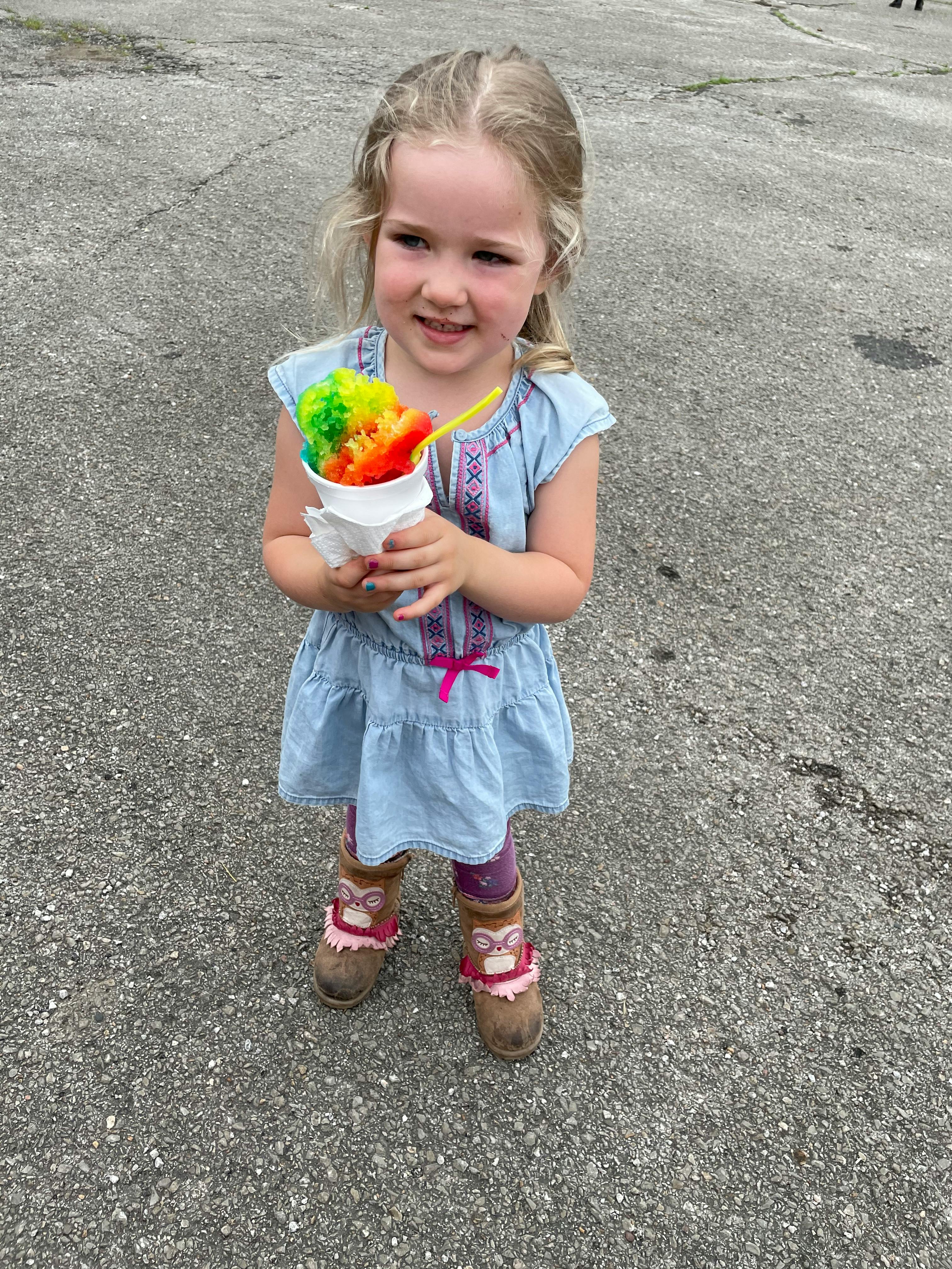 Child holding a colorful snow cone