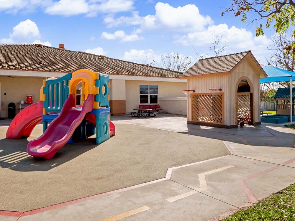 Playground with colorful slides and a small playhouse