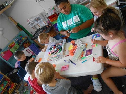 Adult and children doing crafts at a table