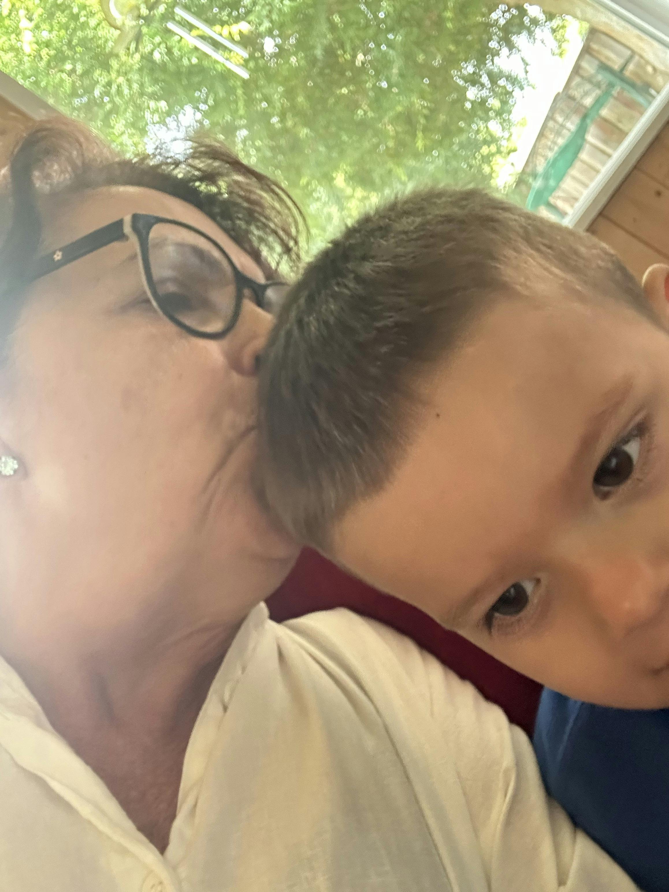 Person in glasses kissing a child on the head