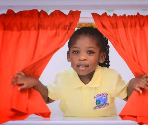 Child peeking through red curtains