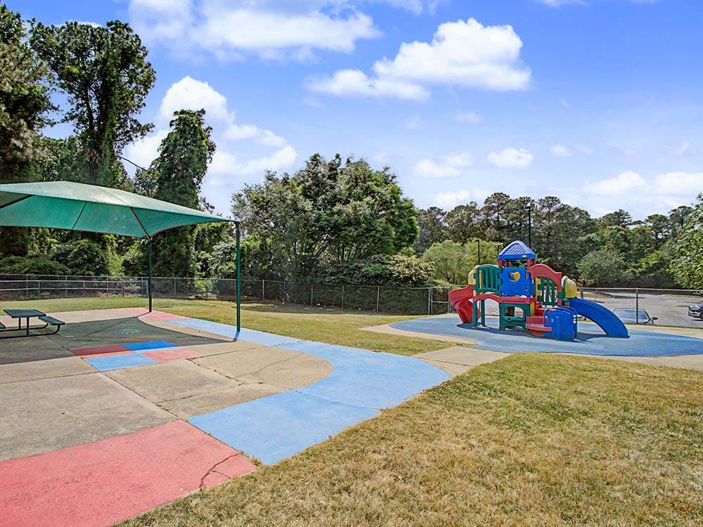 Colorful outdoor playground with slides and a covered seating area