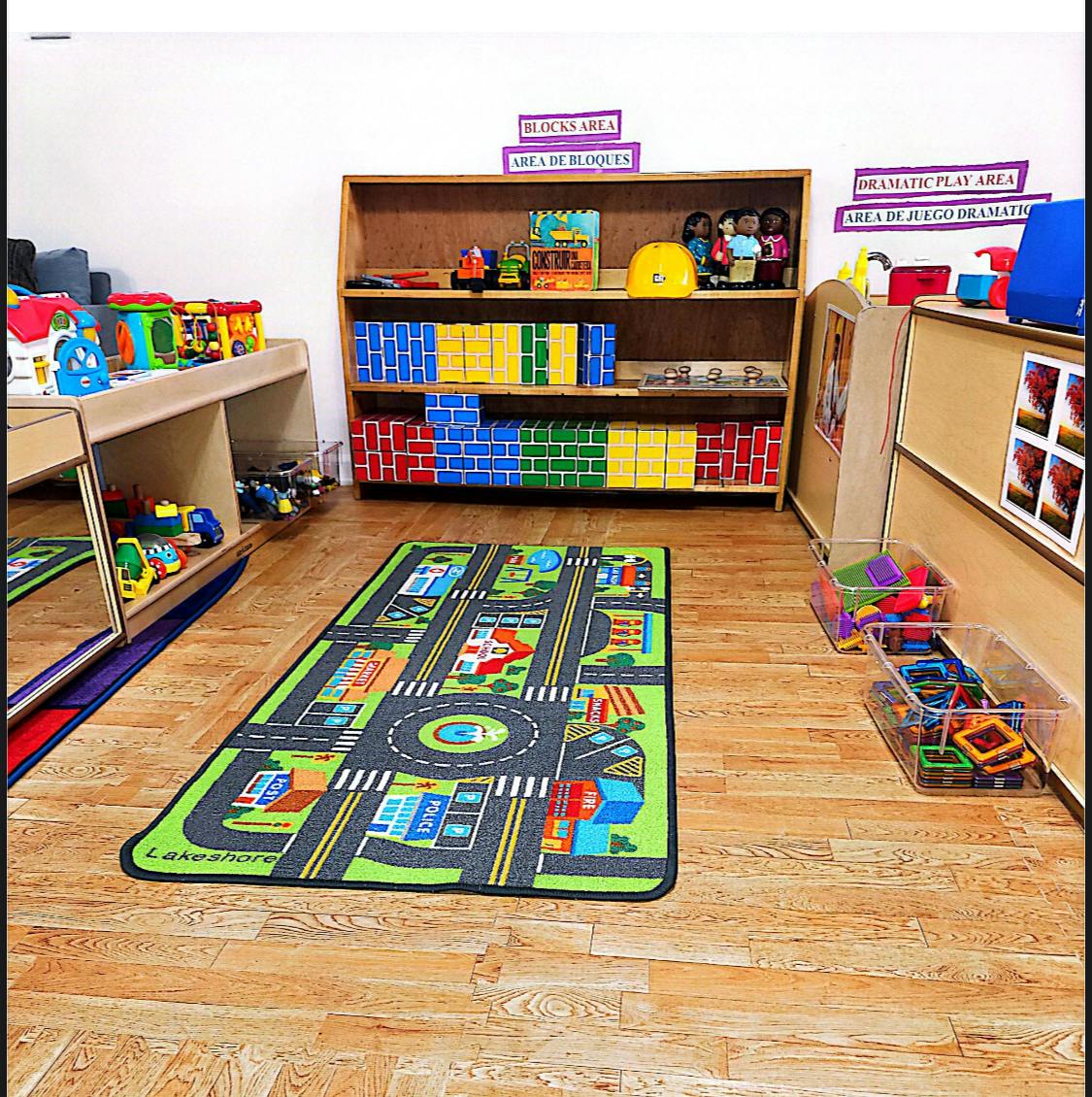 Playroom with a road map rug, shelves of blocks, and toys