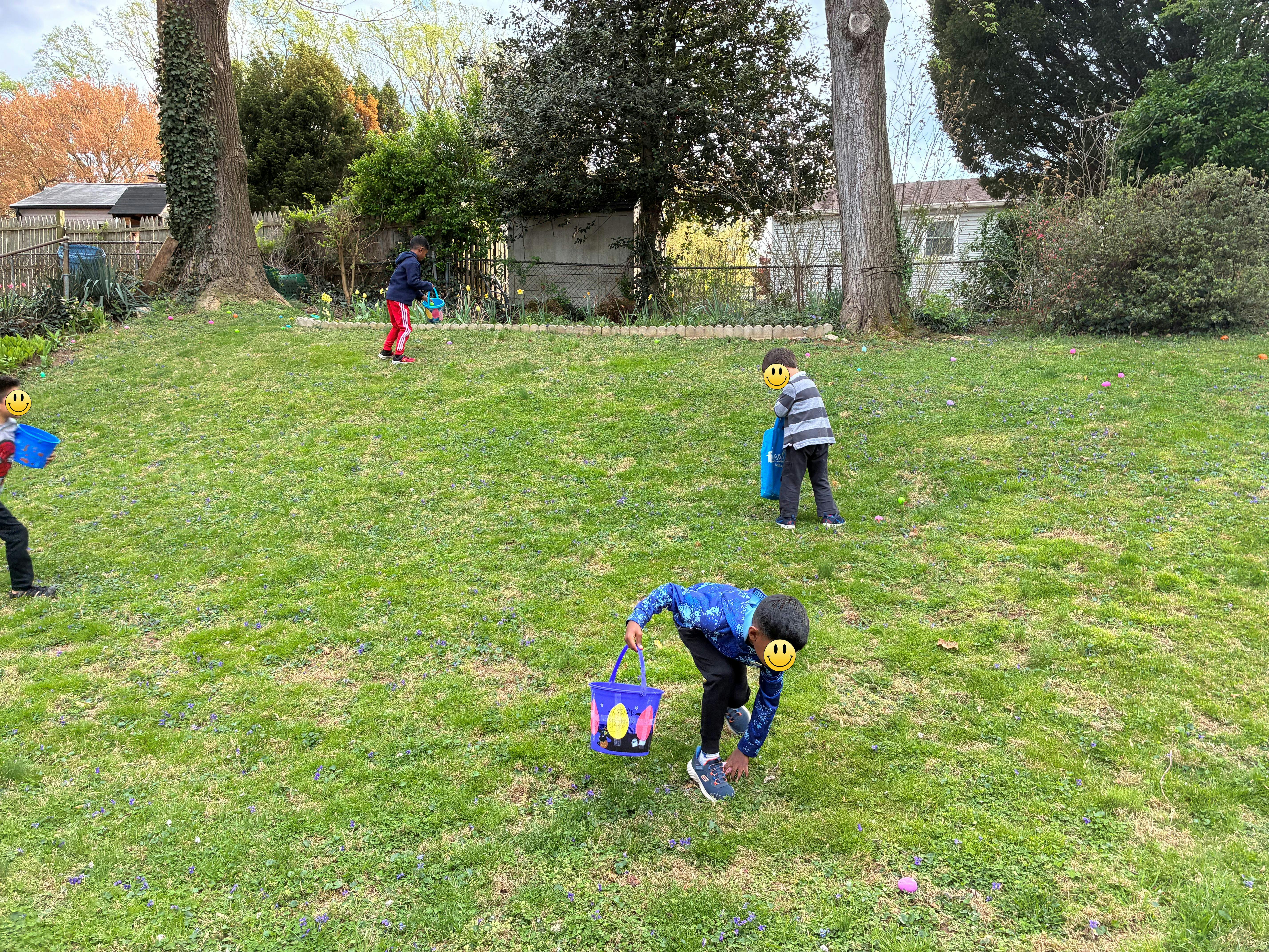 Children collecting Easter eggs in a backyard