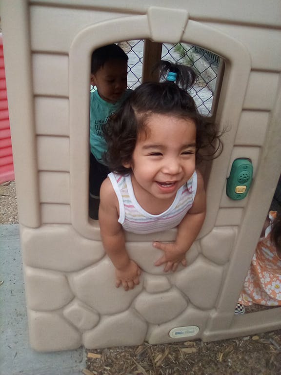 Child looking out of a playhouse window