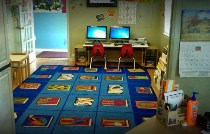 Classroom with computers and a colorful rug