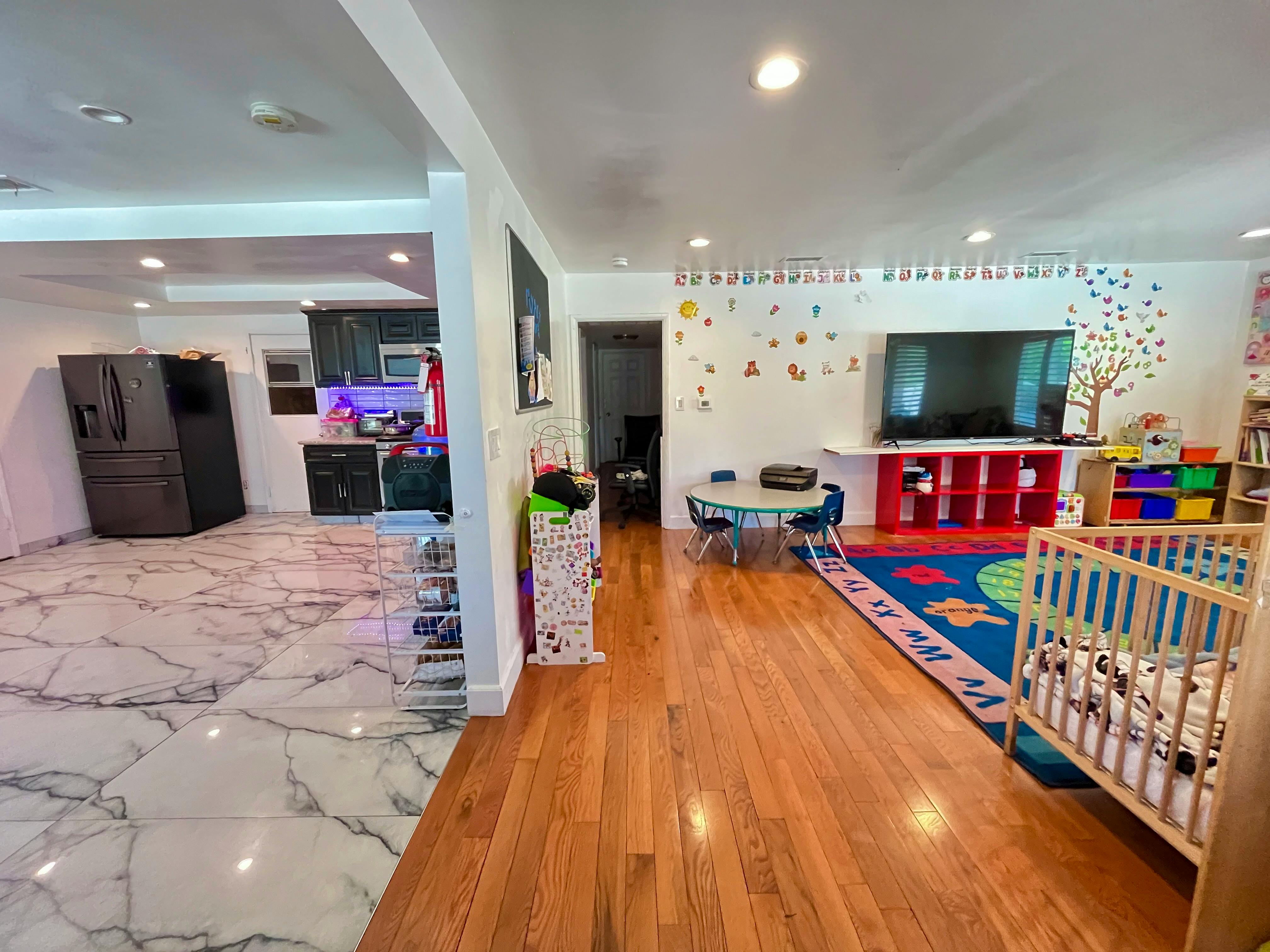 Living area with hardwood floor and a kitchen with marble floor