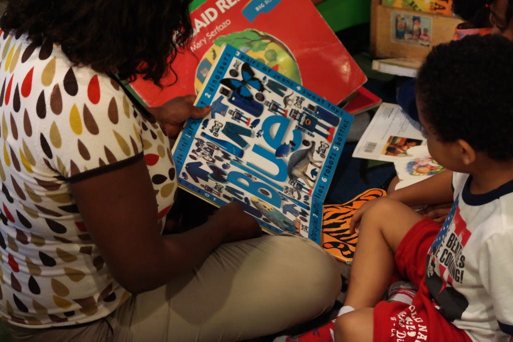 Person and child looking at a blue board game with letters