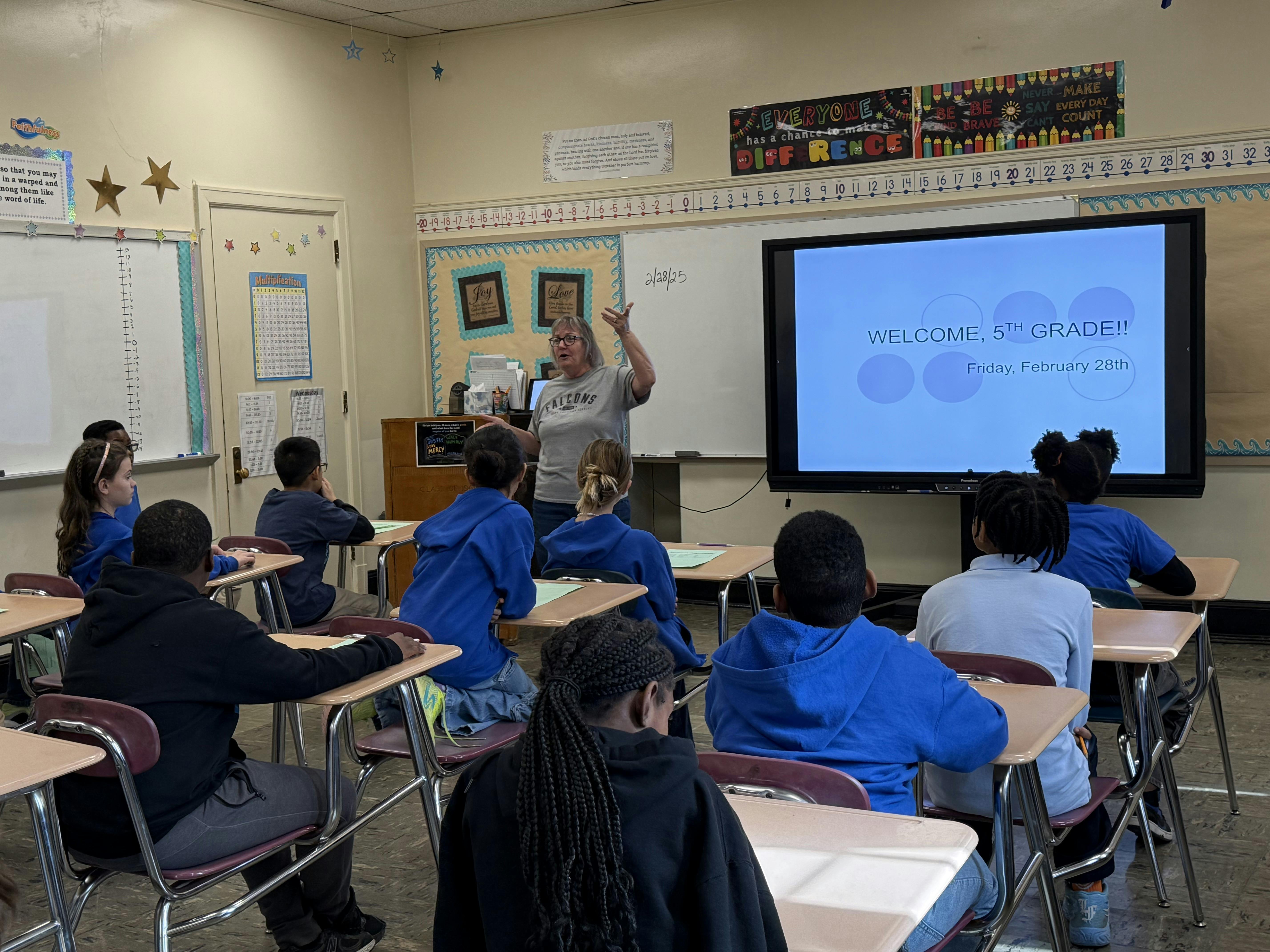 Person teaching a class of children in a classroom