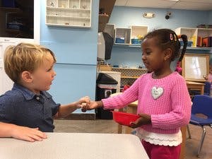 Two children interacting in a classroom