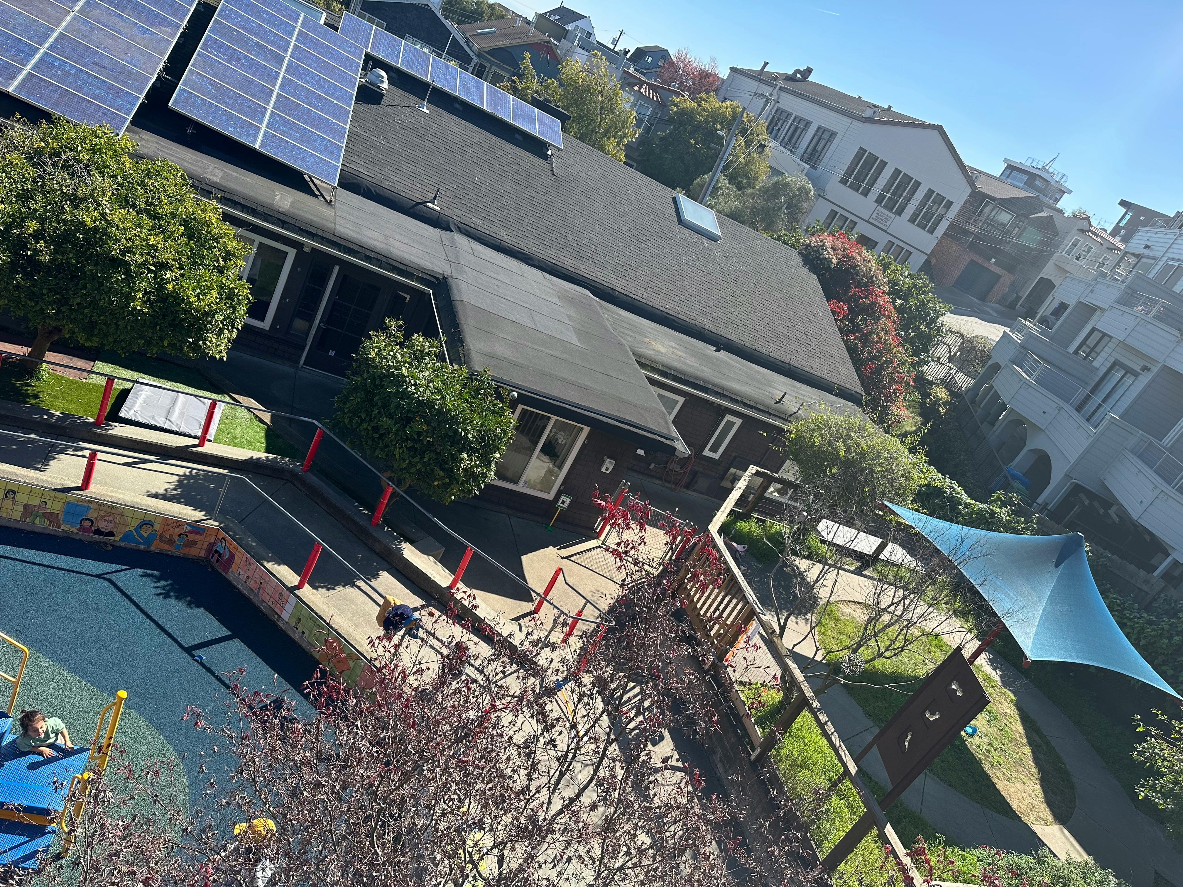 Building with solar panels on the roof and a pool in the foreground