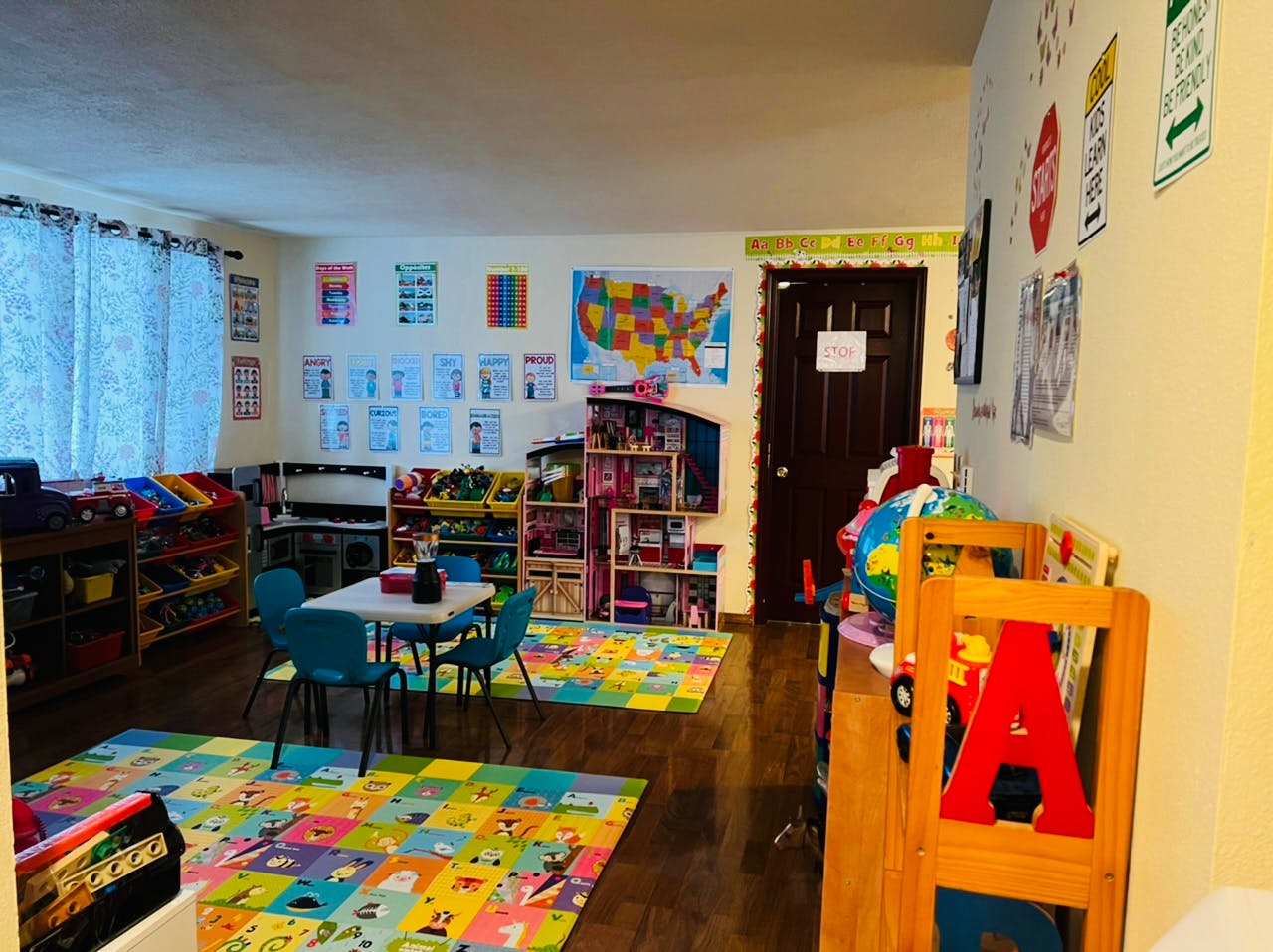 Classroom with colorful rugs, small tables, and educational posters
