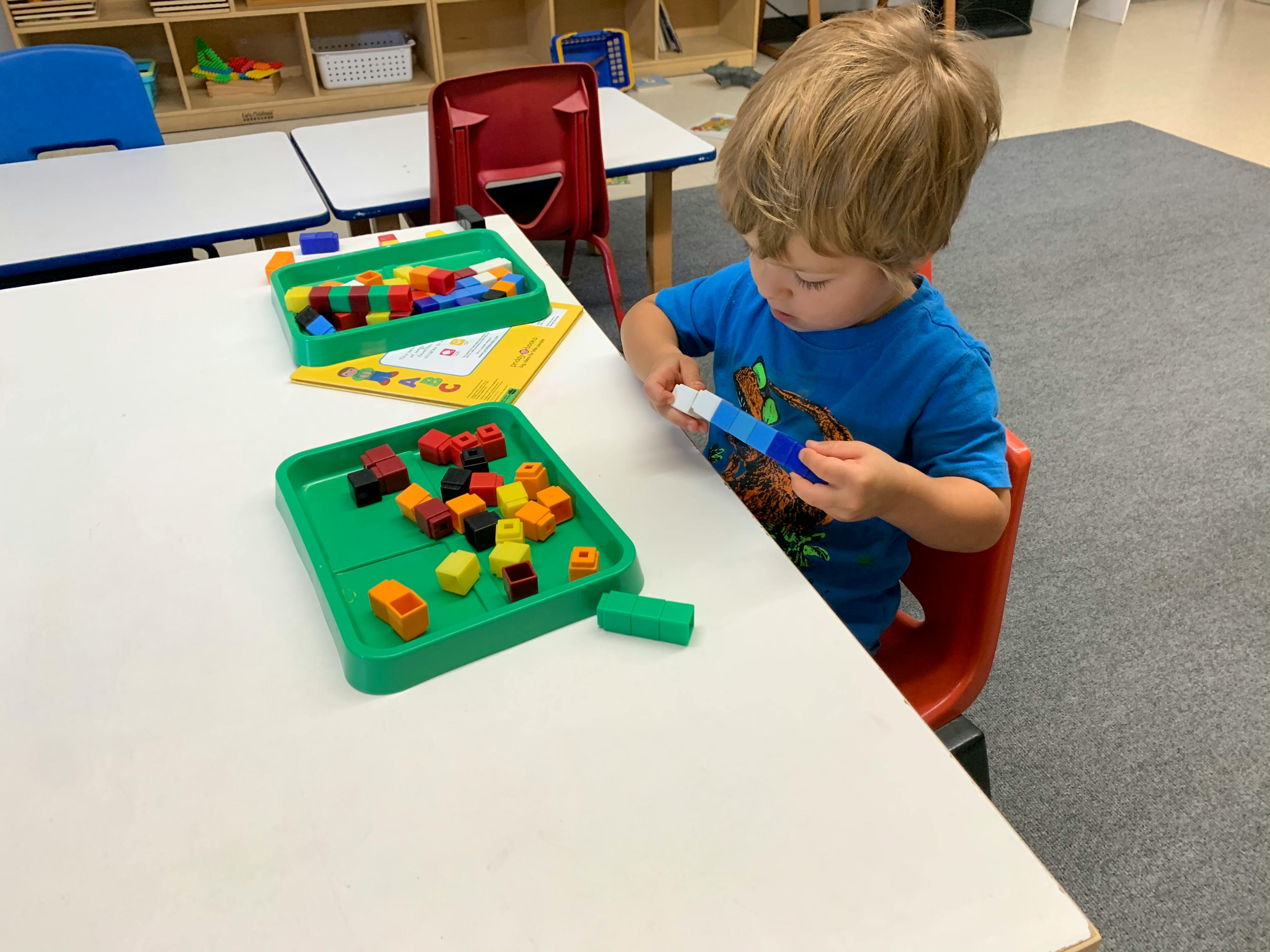 Child playing with colorful building blocks at a table