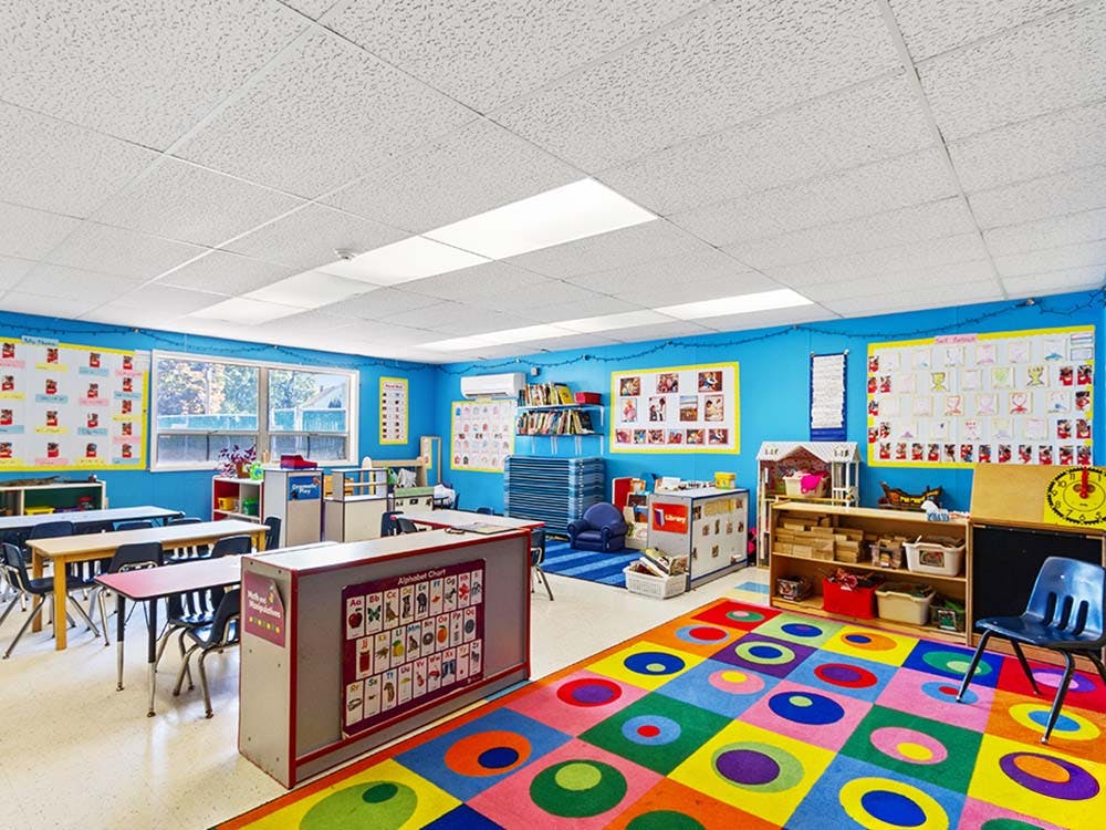 Empty colorful classroom with small tables and chairs