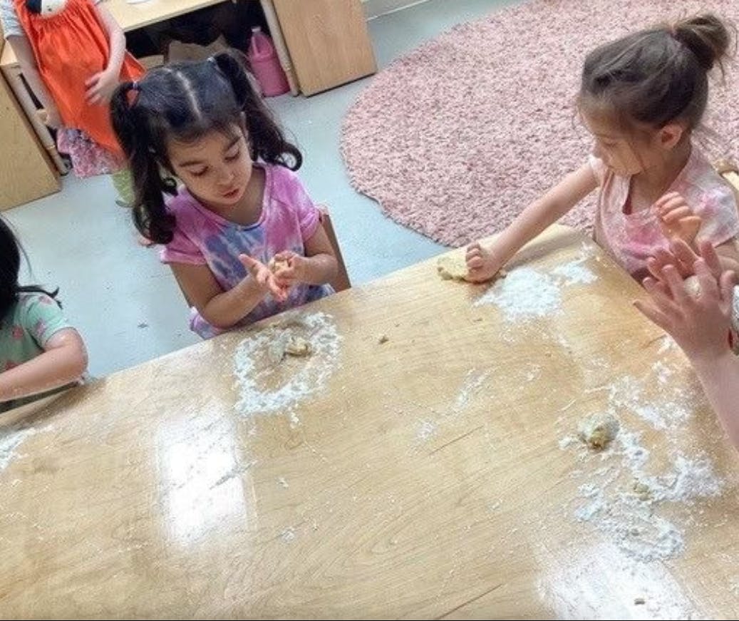 Children at a table with flour and dough
