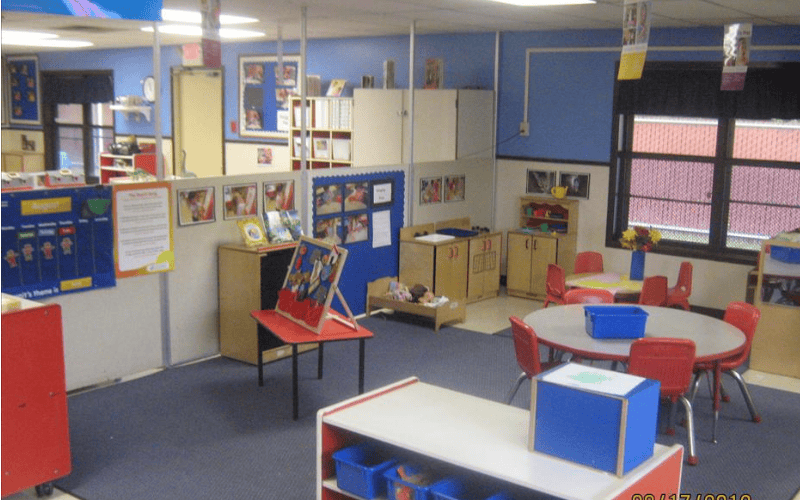 An empty classroom with small tables and chairs