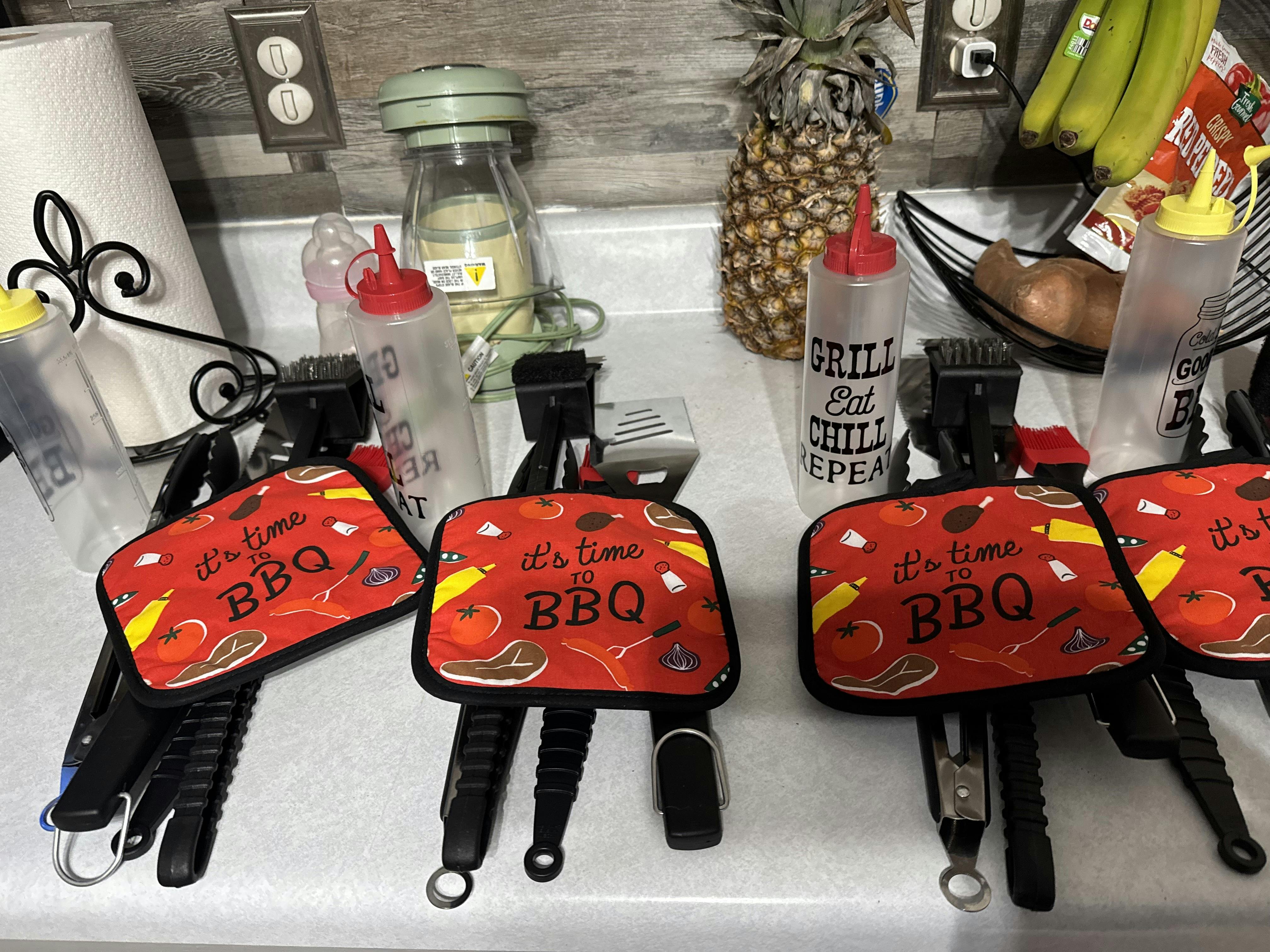 Multiple barbecue tool sets with red mitts that say "It's time to BBQ"