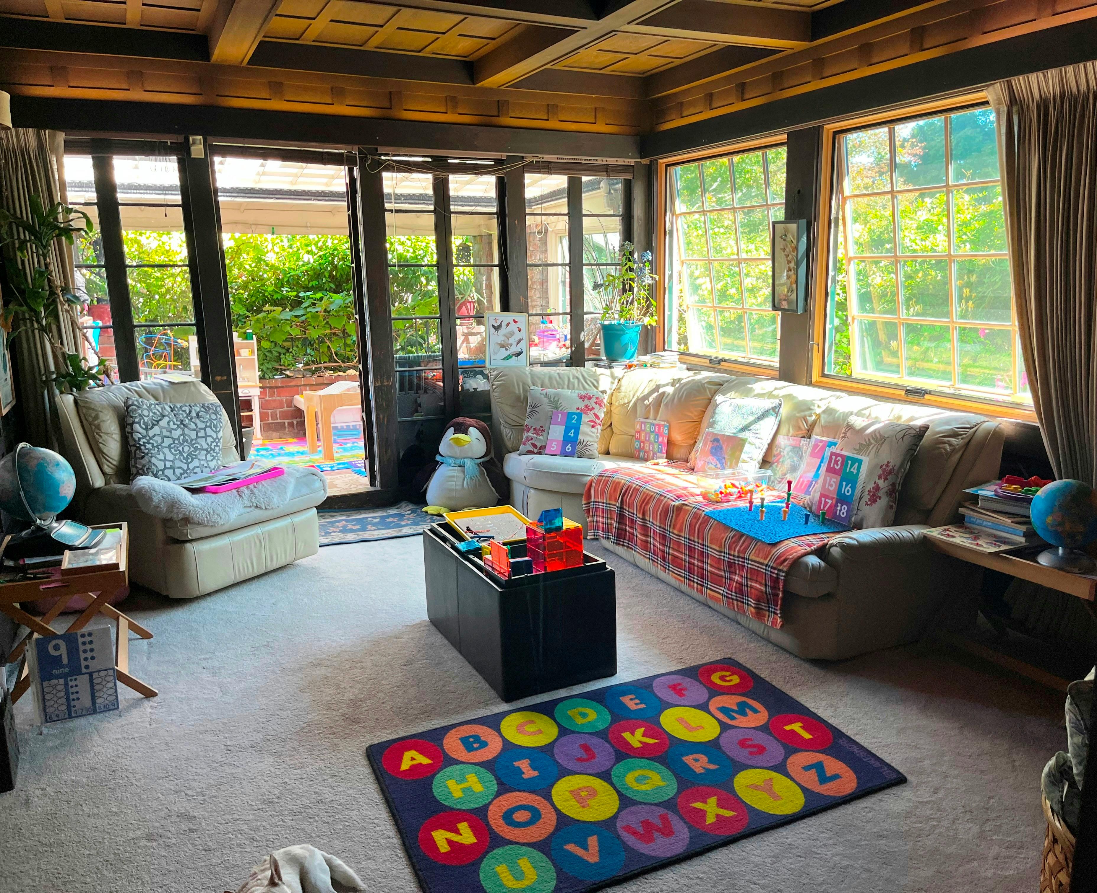 Living room with furniture and educational toys including an alphabet rug
