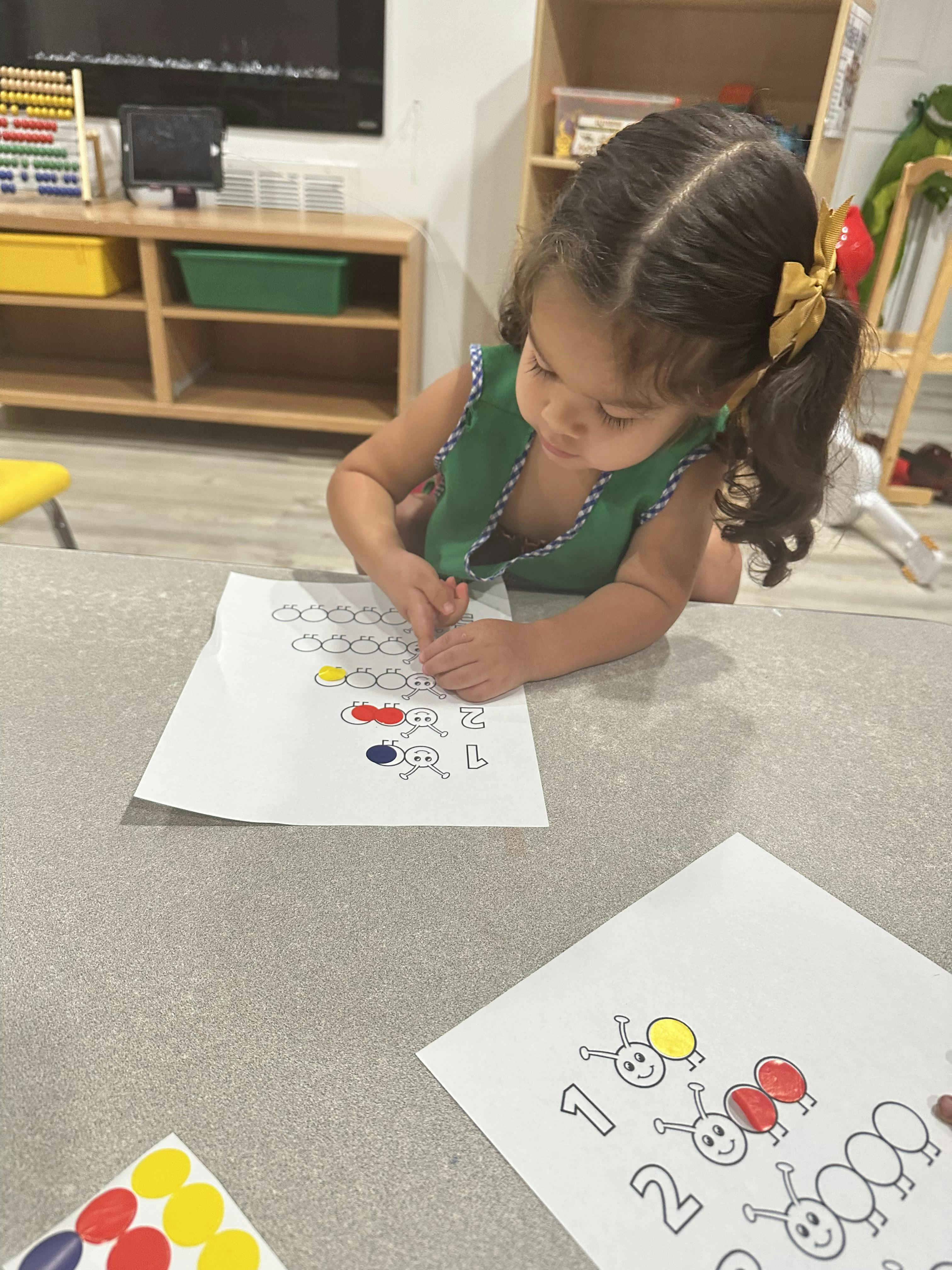 Child coloring a worksheet on the floor