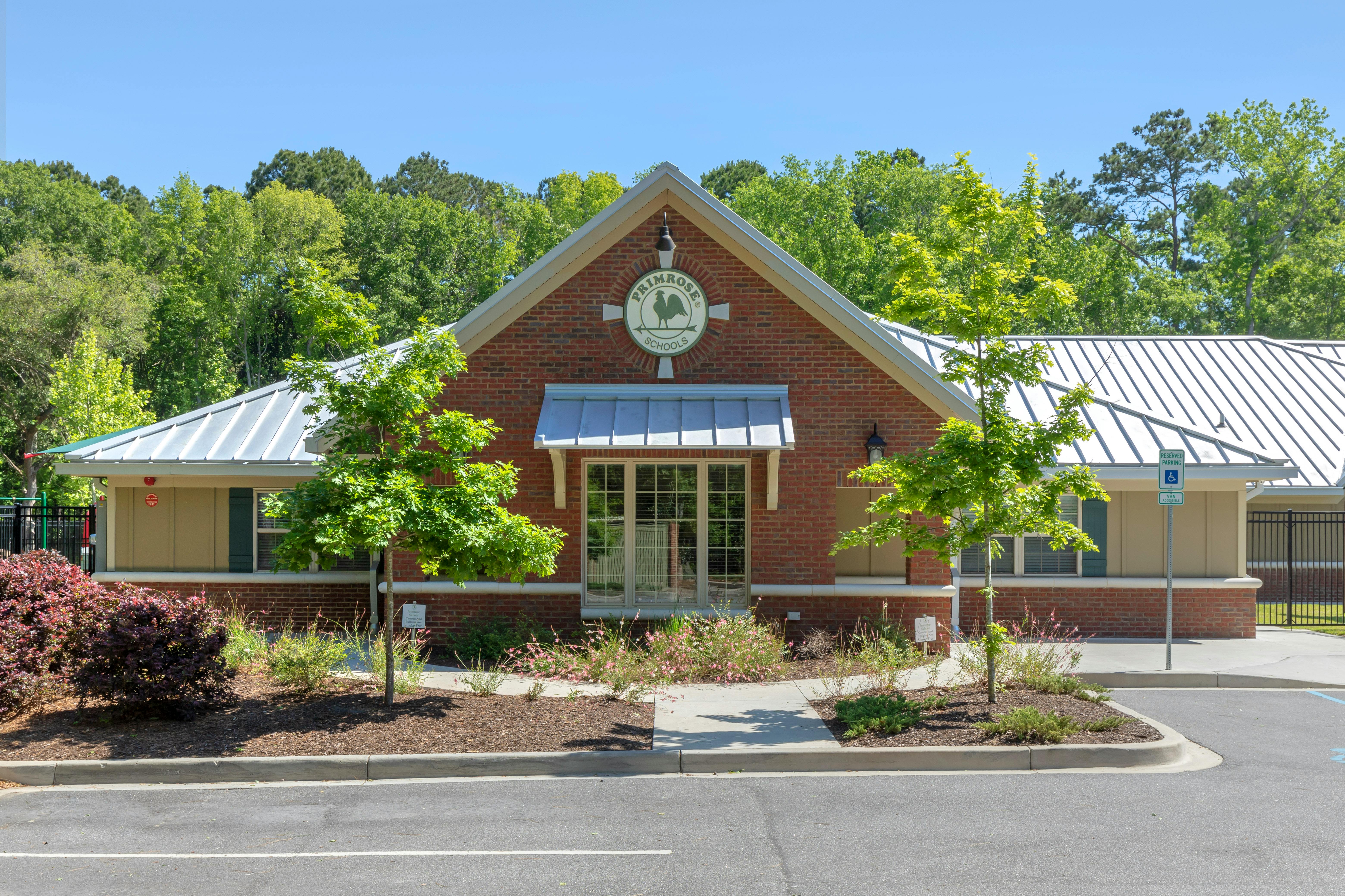 Primrose Schools building entrance with red brick facade and a green logo
