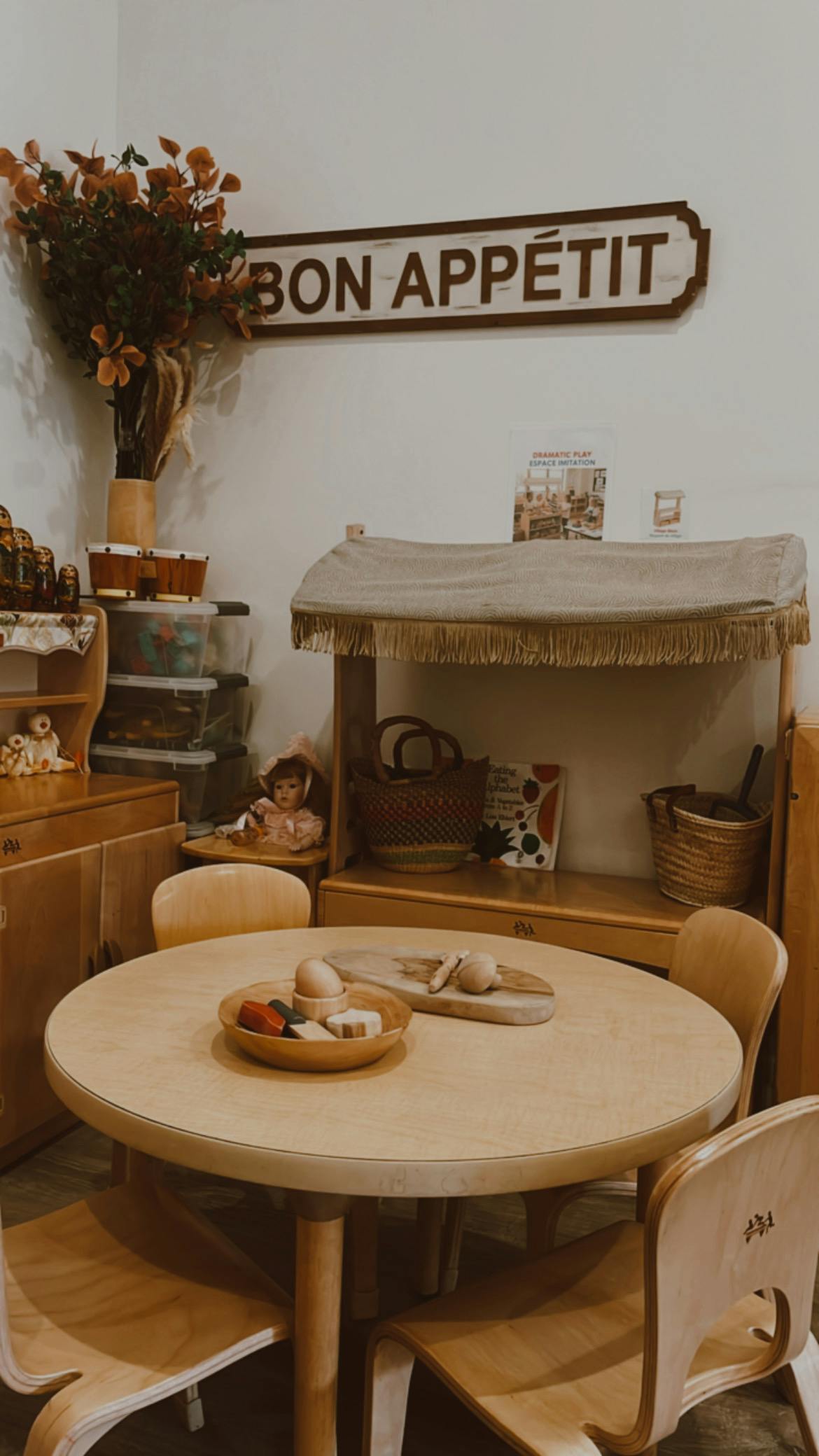 Wooden play table and chairs with toy food in a classroom setting