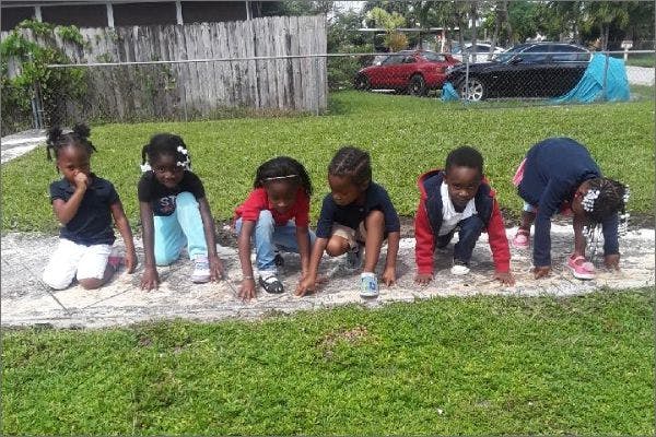 Five children in starting positions on a grassy area