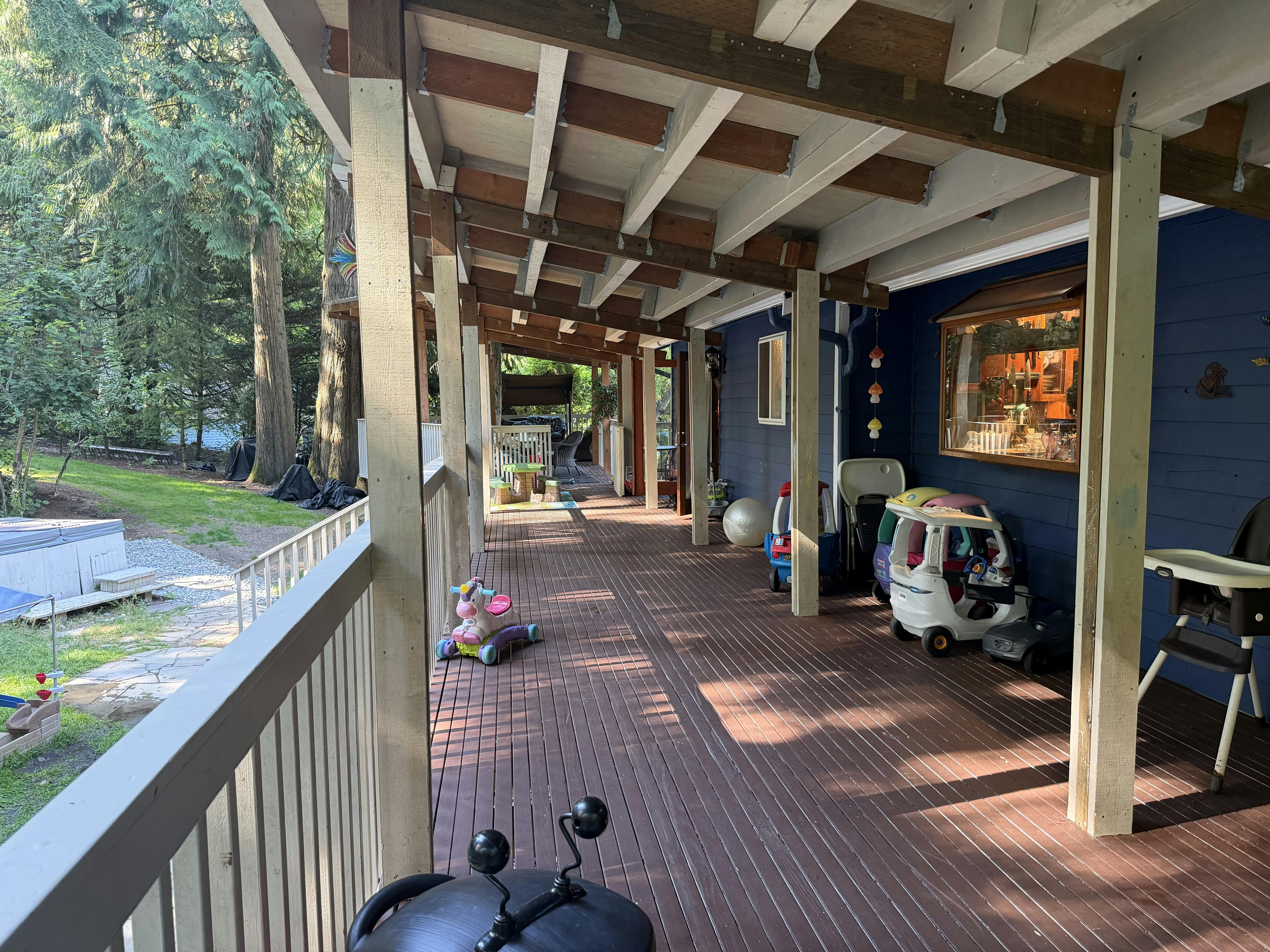 Covered wooden deck with outdoor toys and child furniture