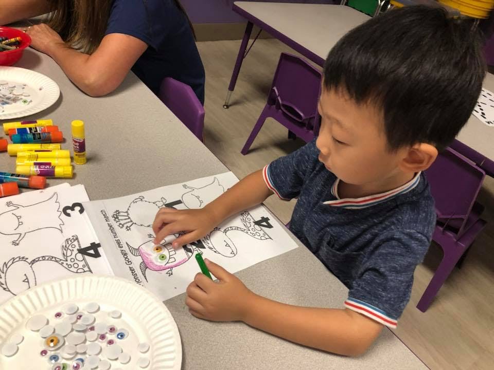 Child coloring a picture at a table